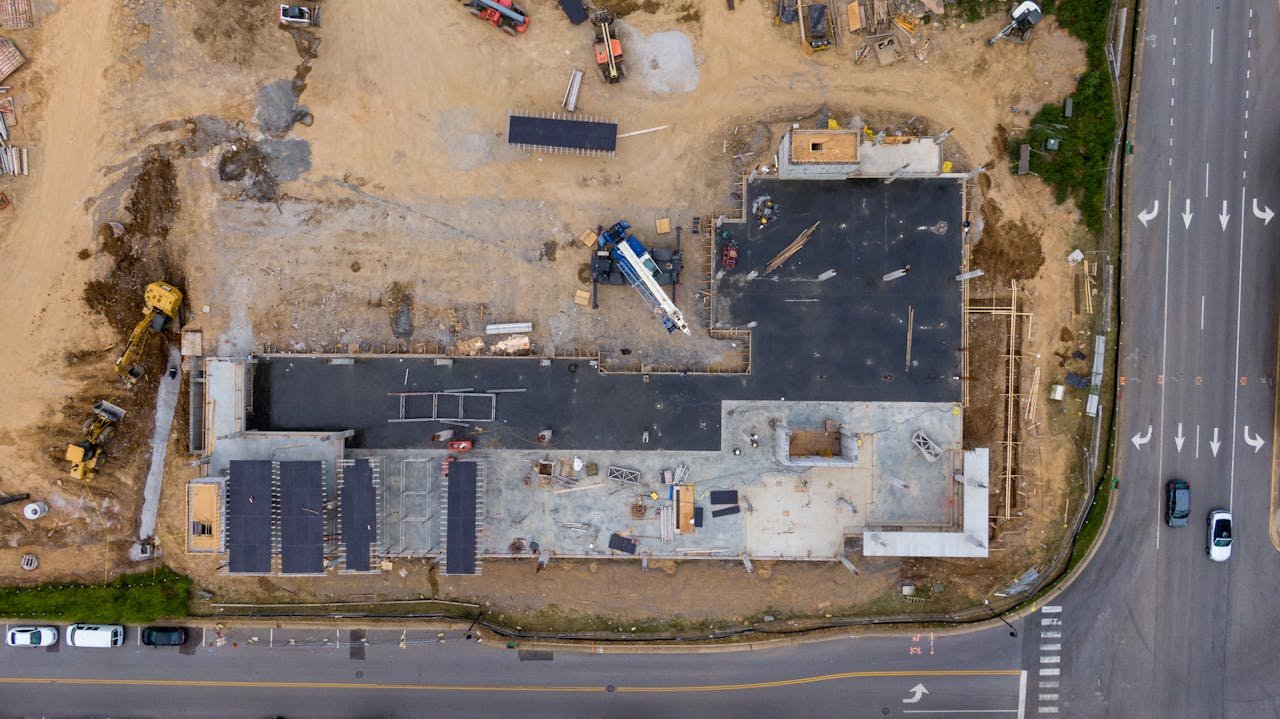 Inicio Aerial view of an active construction site with machinery and vehicles.
